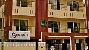 A multi-story building with a central red column, multiple balconies, and a sign indicating it is a Stamford property. - Stamford Residency (Bengaluru)