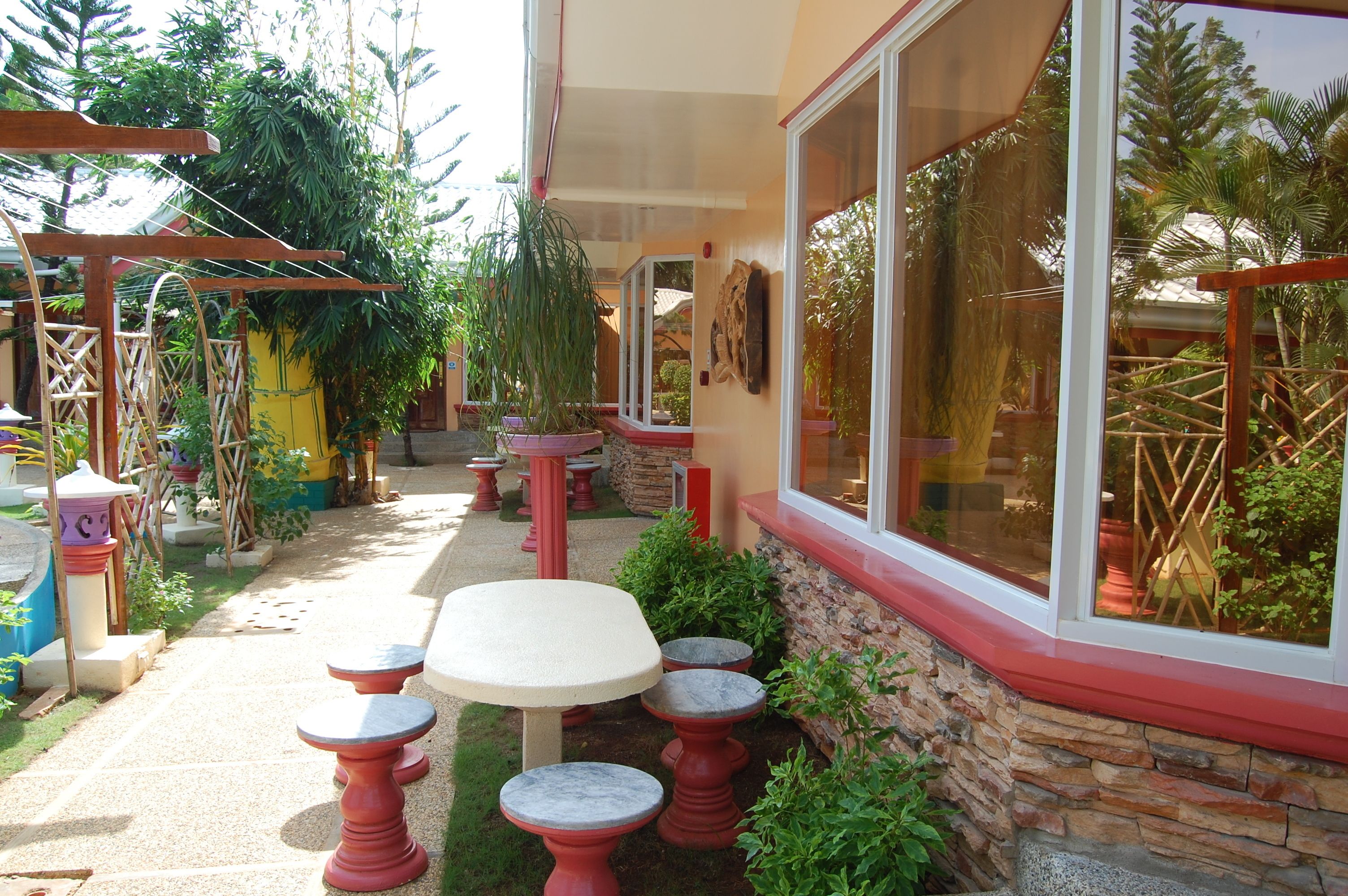 A patio area with outdoor seating, stone walls, and potted plants.