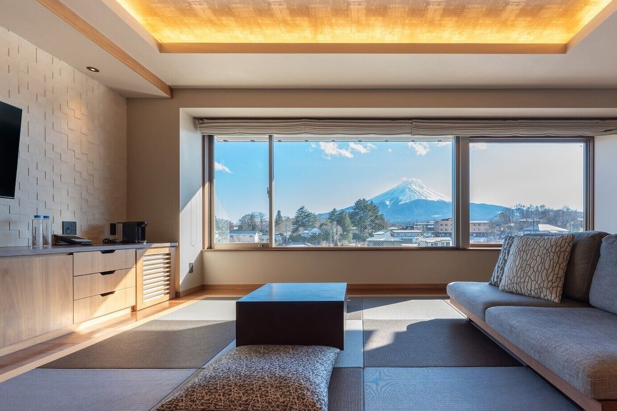 A modern living room with a sofa, a coffee table, and a TV on a wall.