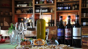 Een tafel met diverse soorten eten en wijnflessen.