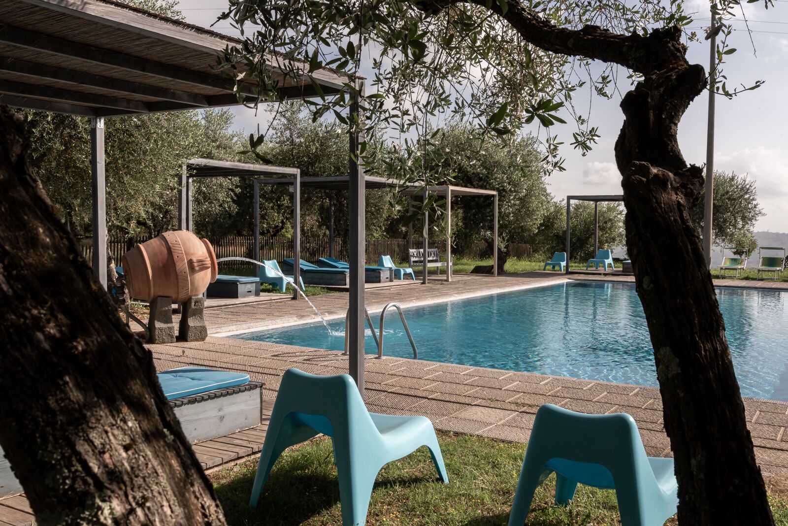 A swimming pool with lounge chairs and a pergola structure.