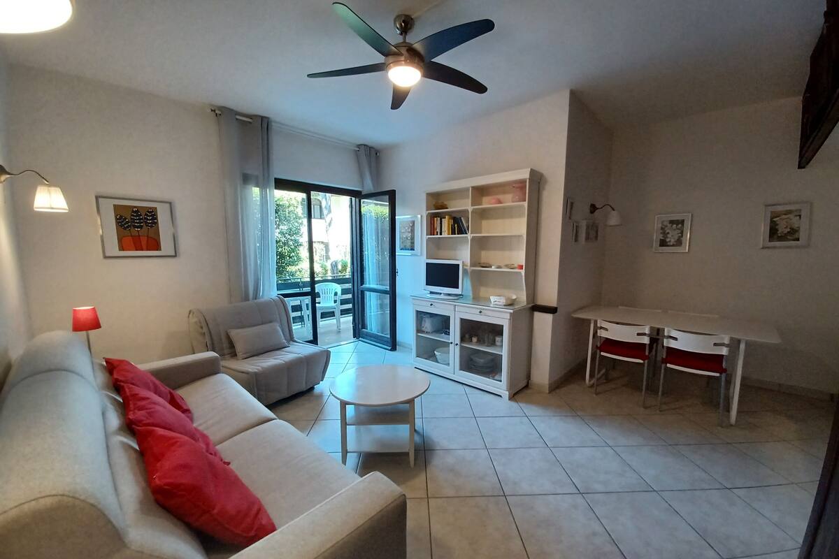 A living room with a sofa, a small table, a TV, and a bookshelf.