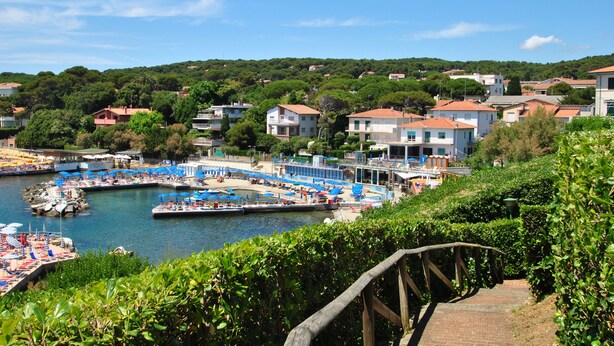 A coastal town with a marina, buildings, and a staircase leading down to the water. - Fattoria nel Parco (Rosignano Marittimo)