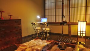 A traditional Japanese room with tatami flooring, a wooden desk with a laptop, a futon, and a tea set. - Hodakaso Yamanoiori (Takayama)