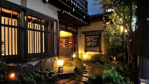 A traditional Japanese building with a stone pathway, lanterns, and a wooden fence. - Hodakaso Yamanoiori (Takayama)