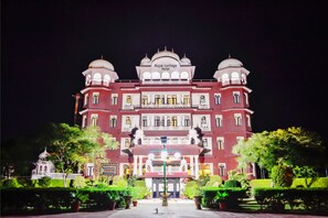 A large, ornate building with a sign reading "Royal Heritage Hotel" at the top.