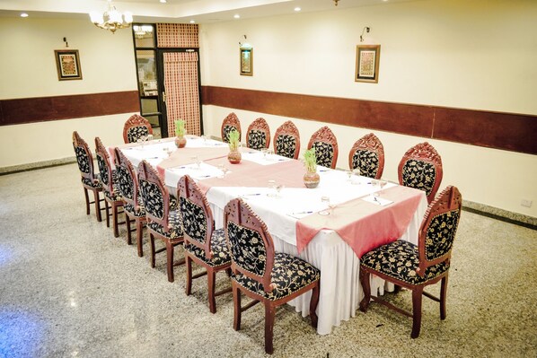 A conference room with a long table, chairs, and a carpeted floor.