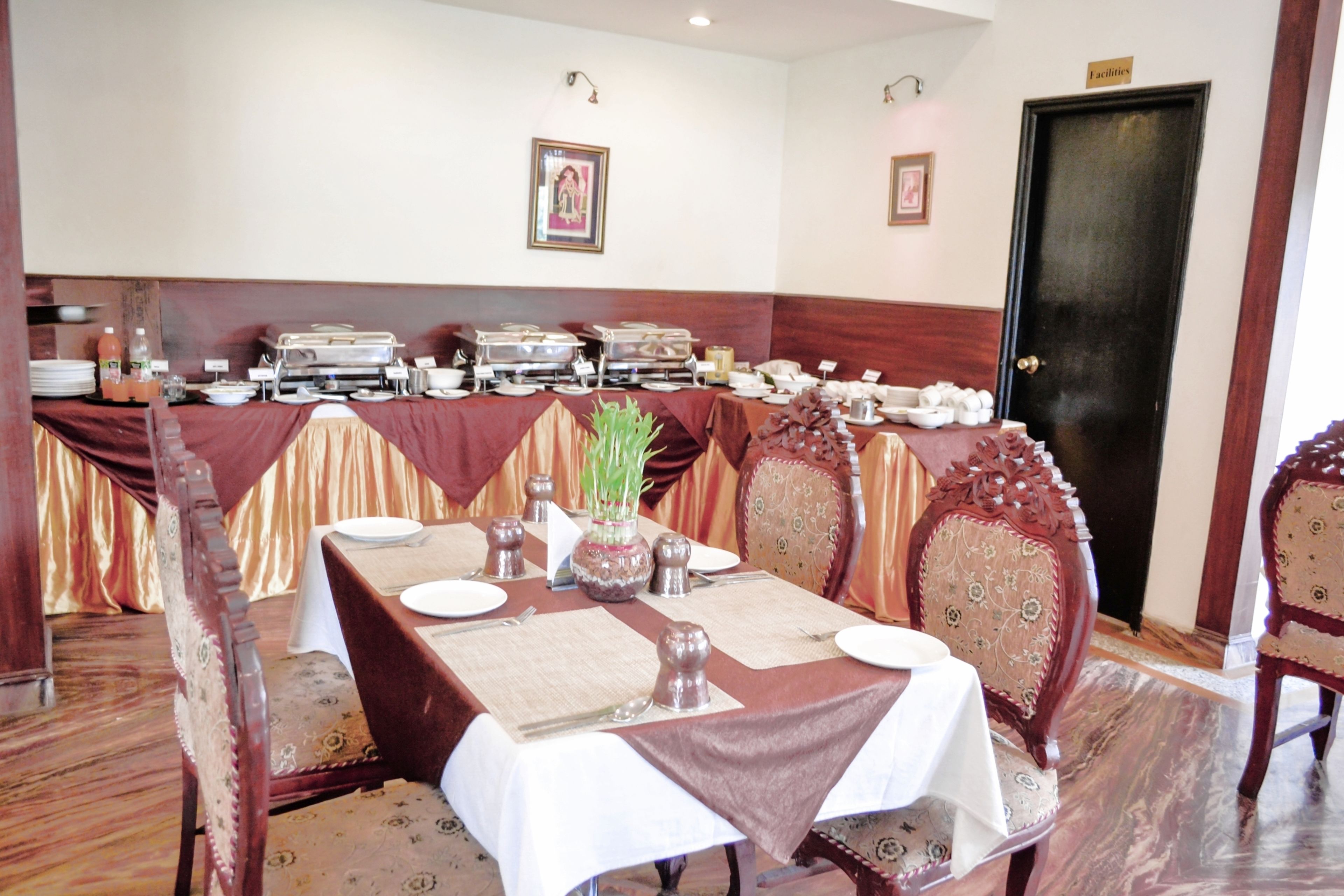 A dining area with a long table set for a meal, surrounded by ornate chairs.