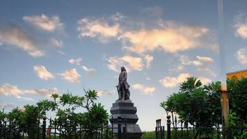 A statue in a park with a clear sky and trees.