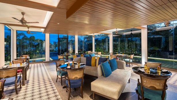 Amplia sala de estar con techos altos, ventanas grandes y vistas al exterior.