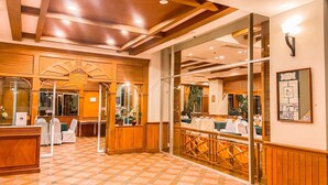 A hotel lobby with a check-in counter, seating area, and a view of the dining area. - K Park Grand Hotel (Surat Thani)