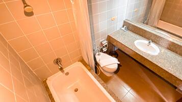 A bathroom with a bathtub, two sinks, and a shower.