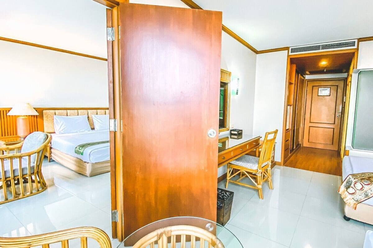 Une chambre d’hôtel comprenant un lit, un bureau, une chaise, une table et une armoire.