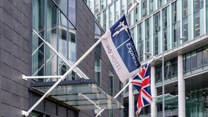 A flag with 'ANIING HOTEL' and 'Express' text, a British flag, and a modern building with large windows. - Holiday Inn Express Birmingham - Snow Hill by IHG (Birmingham)