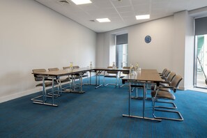 A conference room with a long table, chairs, and a clock on the wall. - Holiday Inn Express Birmingham - Snow Hill by IHG (Birmingham)