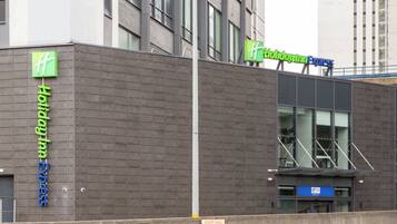 Un edificio moderno con il cartello Holiday Inn Express, il logo Holiday Inn Express e un segnale che indica 'Snow Hill Queensway 4'.