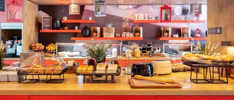 Um buffet de café da manhã com diversos alimentos e uma máquina de café.