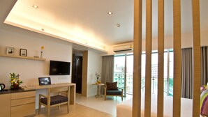 Une chambre d’hôtel moderne équipée d’un bureau, d’une chaise, d’un lit et d’un balcon avec vue.
