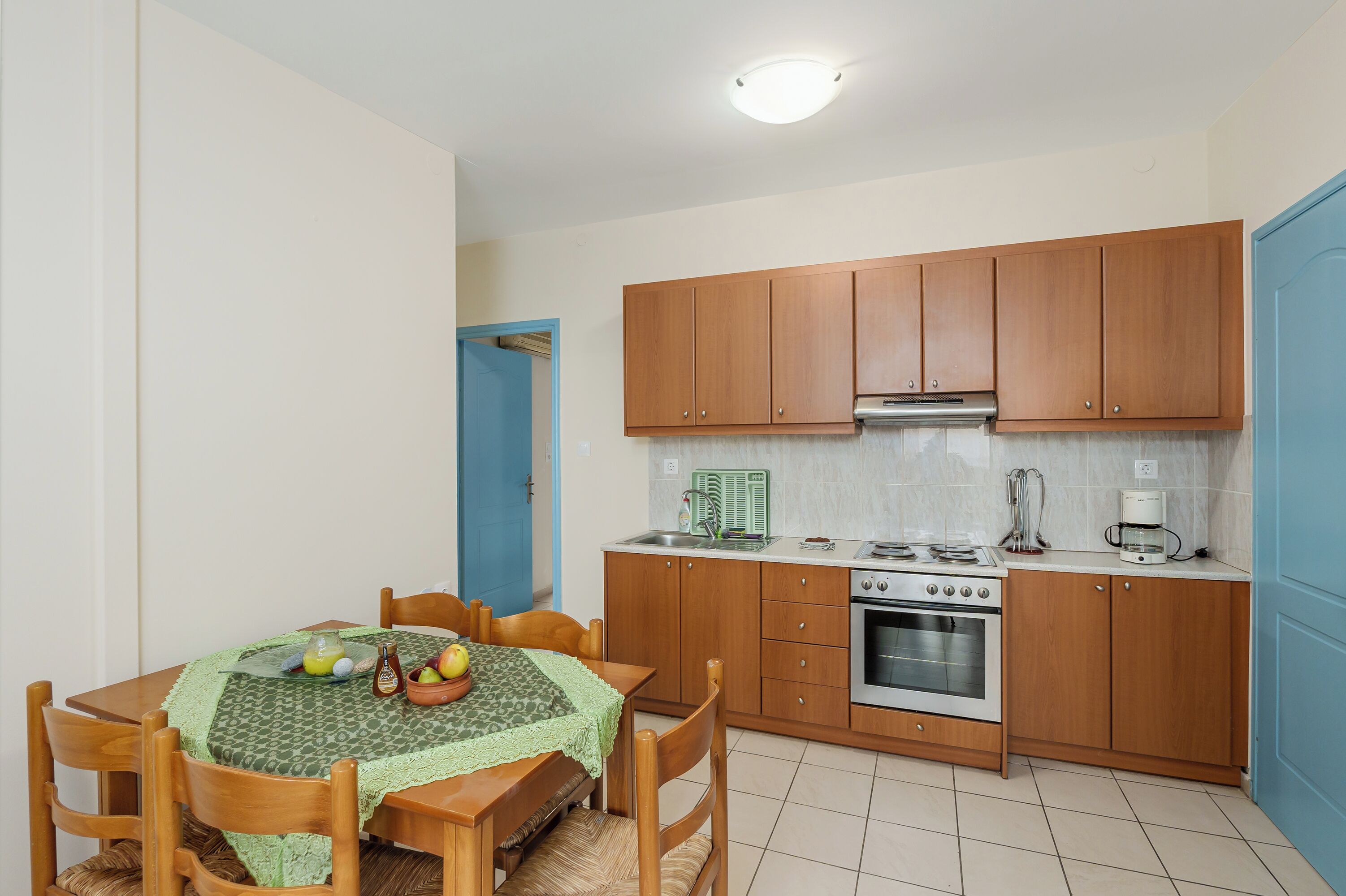 A compact kitchen with wooden cabinets, a stove, and a sink.