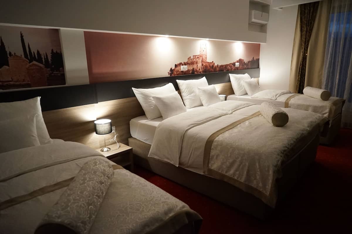 Habitación cuádruple Deluxe | Ropa de cama de alta calidad y caja de seguridad en la habitación
