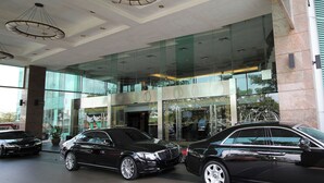 A modern building with large glass windows and a car dealership in front. - Grand Paragon Hotel Johor Bahru (Johor Bahru)