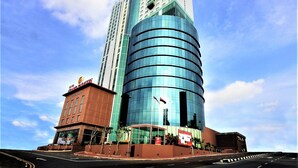 A hotel with a modern glass facade and a traditional brick building adjacent to it. - Grand Paragon Hotel Johor Bahru (Johor Bahru)