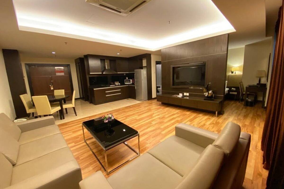 Un salon moderne comprenant un canapé, une table basse, un téléviseur et un coin cuisine.