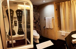 Ein modernes Badezimmer mit einer Duschkabine, einer Toilette und einer Badewanne.