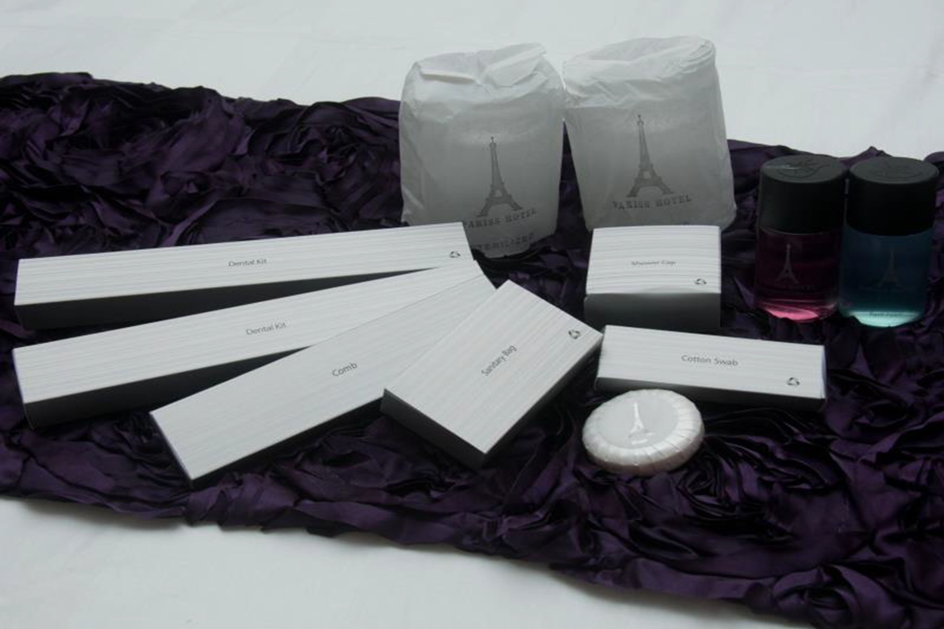 Una colección de productos de cuidado dental, que incluye un peine, un kit dental, un hisopo de algodón y dos botellas de enjuague bucal, todo dispuesto sobre una superficie de tela oscura.