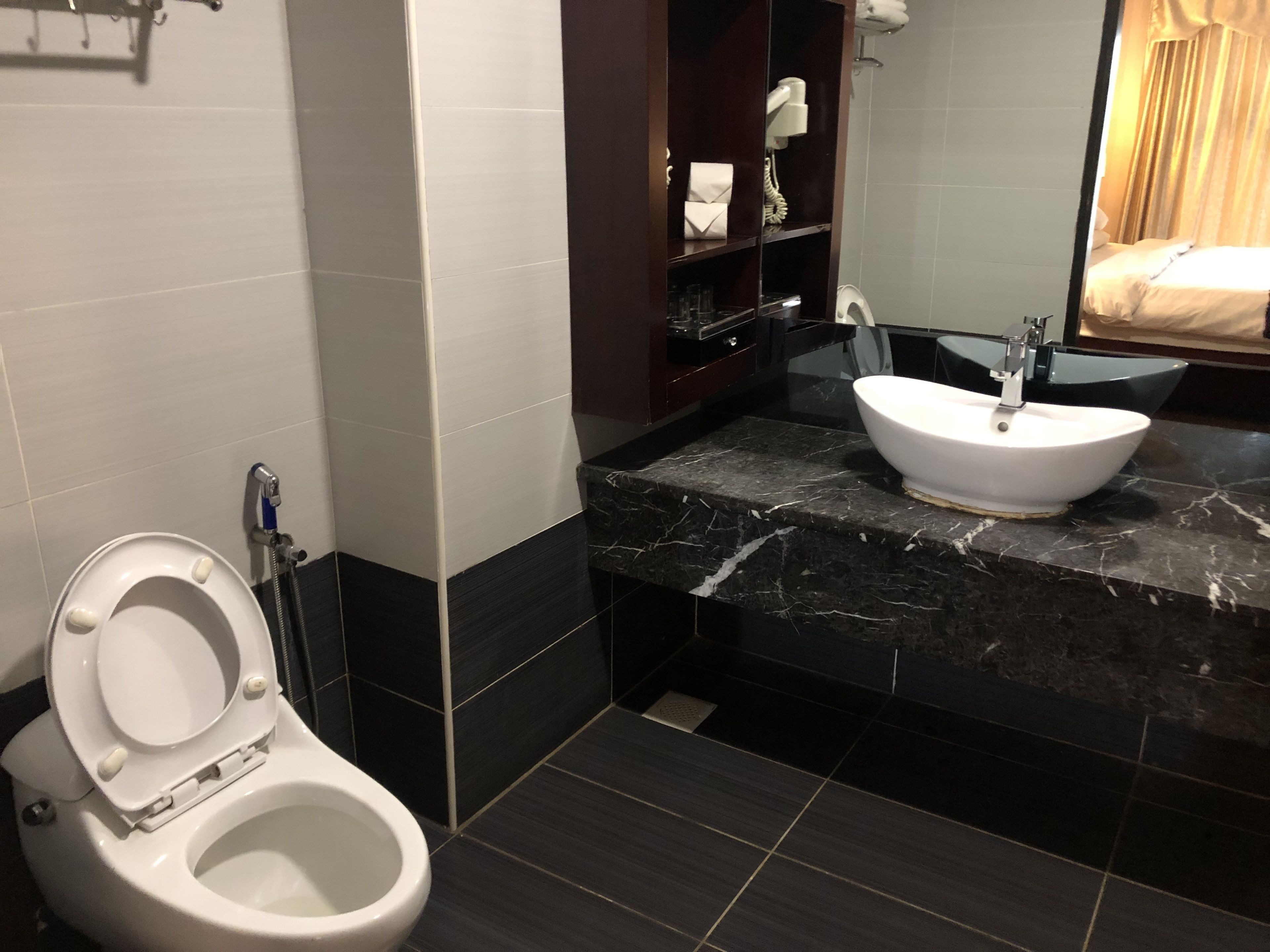 A modern bathroom with a toilet, a sink, and a mirror.