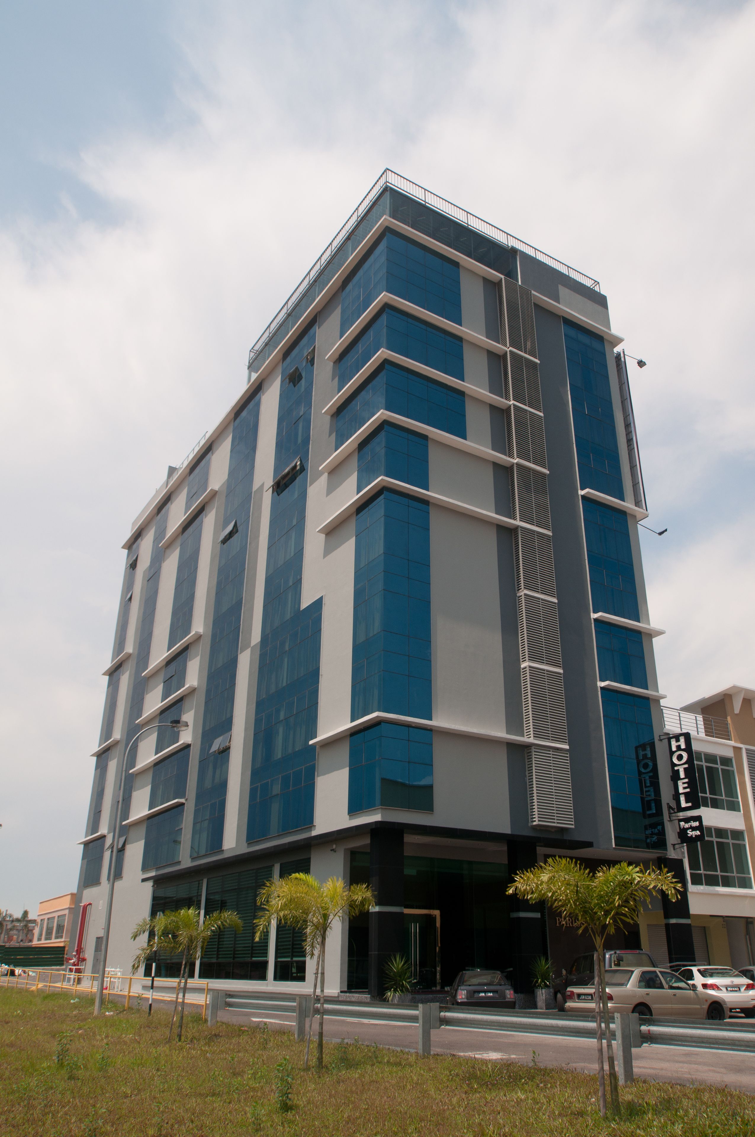 A modern hotel with a multi-story structure, large windows, and a visible entrance.