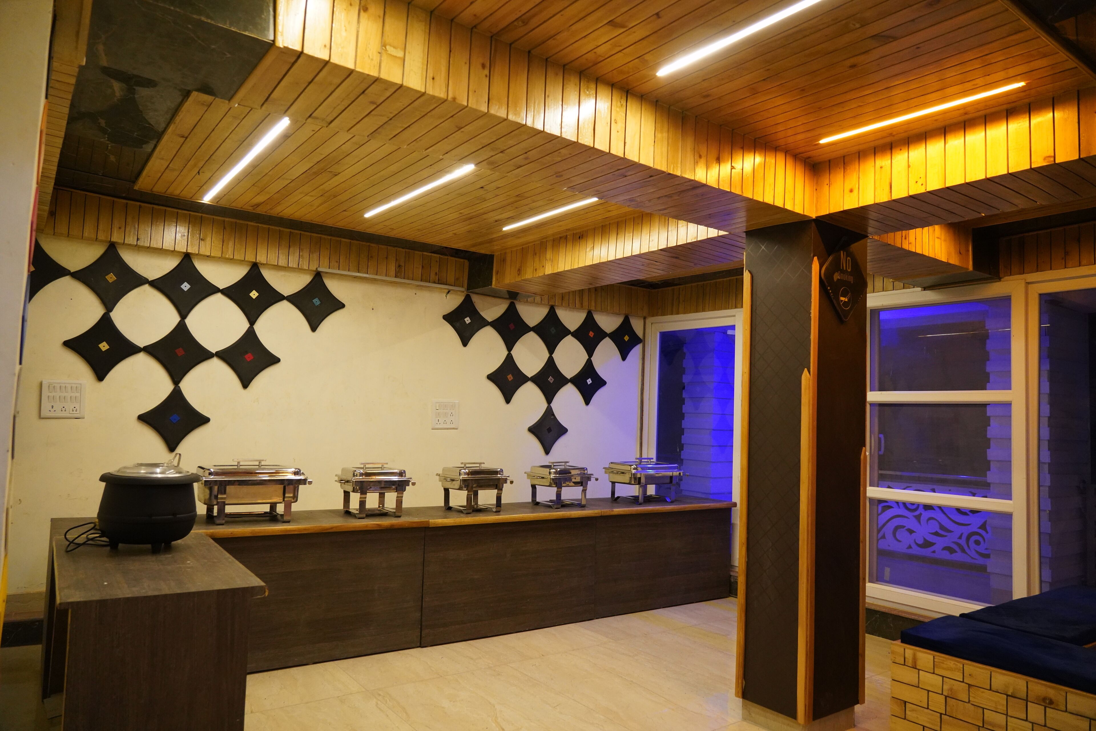 Una cocina con techo de madera, una encimera con electrodomésticos y diseños decorativos en la pared.