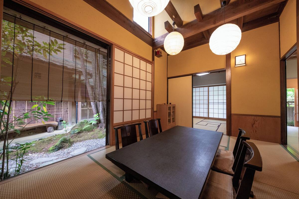 Una habitación japonesa tradicional con suelo de tatami, una mesa baja y puertas correderas.