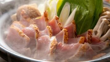 A bowl of food with sliced meat and vegetables.