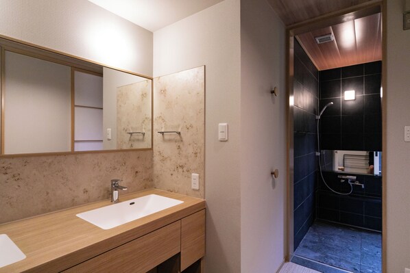 A bathroom with two sinks, a mirror, and a shower area. - Oyado Ichizen (Yufu)