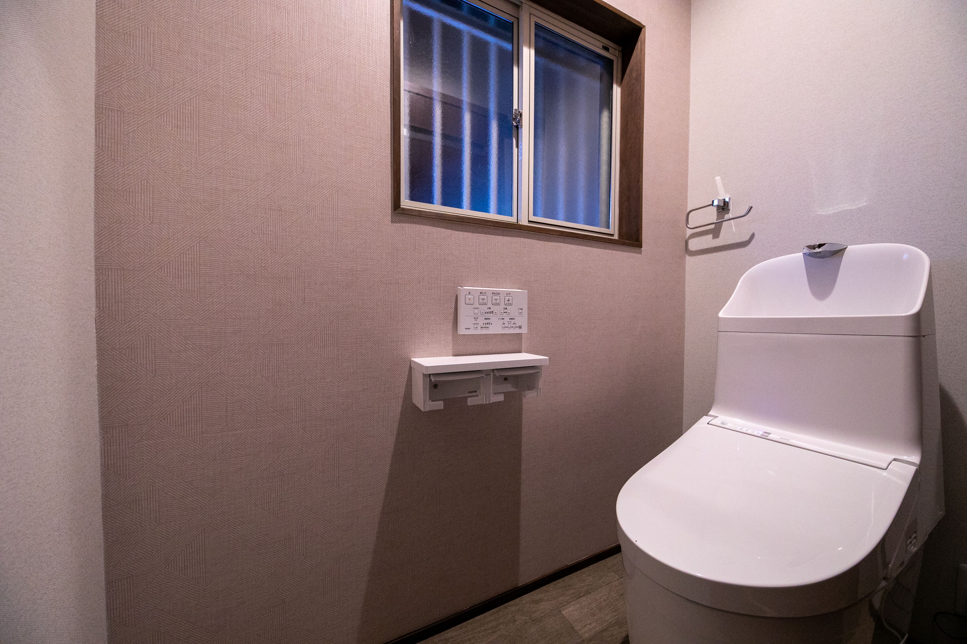 A small, private bathroom with a toilet and a window.