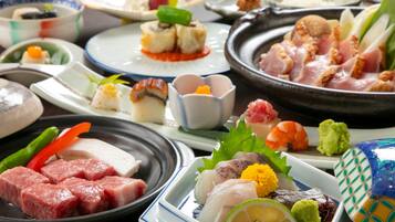A variety of dishes on a table, including sushi, sashimi, and other Japanese cuisine.