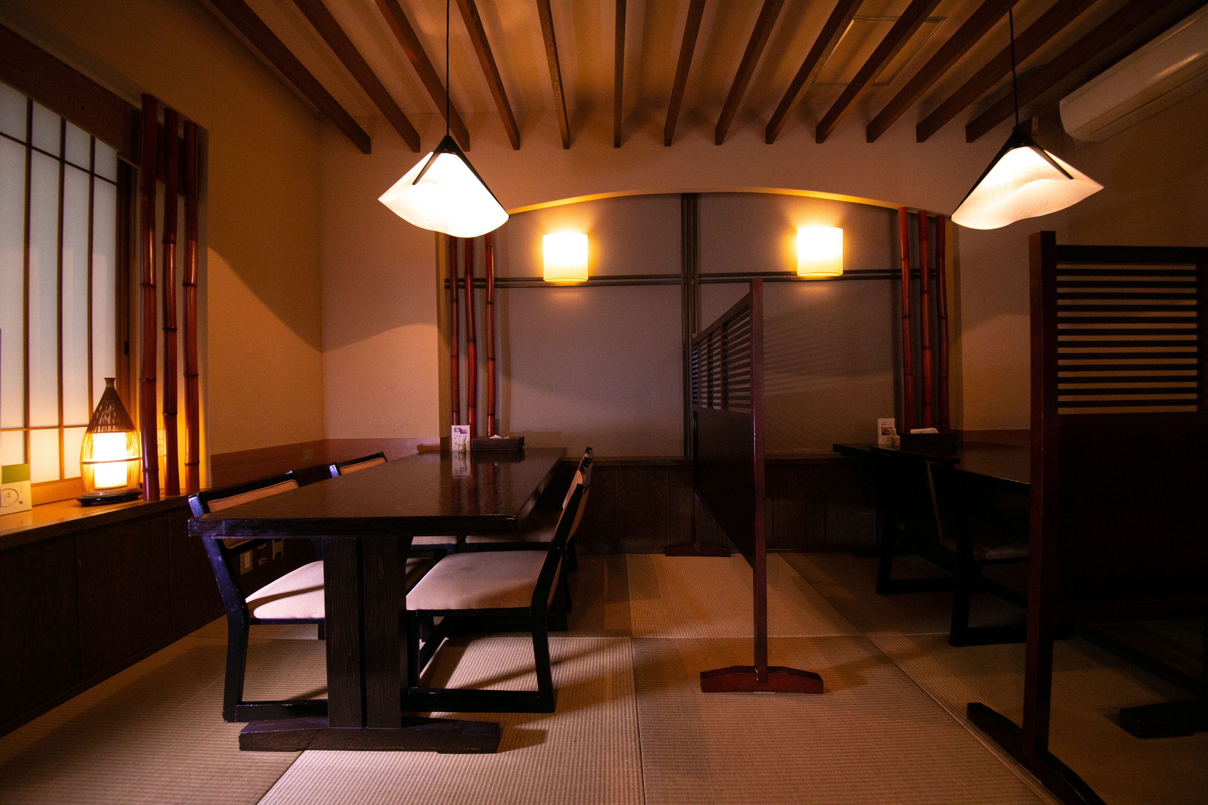 A traditional Japanese-style room with tatami flooring, a low table, and shoji screens.