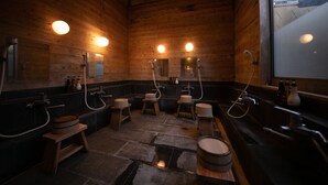 A wooden cabin-style bathroom with four wooden sinks, each with a mirror and overhead lighting. - Oyado Ichizen (Yufu)