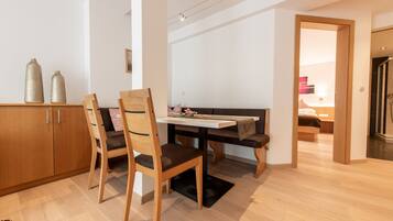 Un intérieur moderne avec une table à manger en bois, deux chaises, un banc et un meuble en bois.