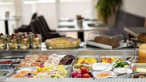A buffet with various food items including meats, cheeses, fruits, and beverages. - Lapis Monti - Apartments & Suites  (Malles Venosta)