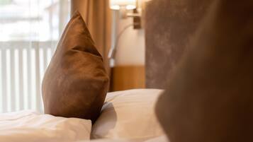 A close-up of a bed with a brown pillow and a white pillow.