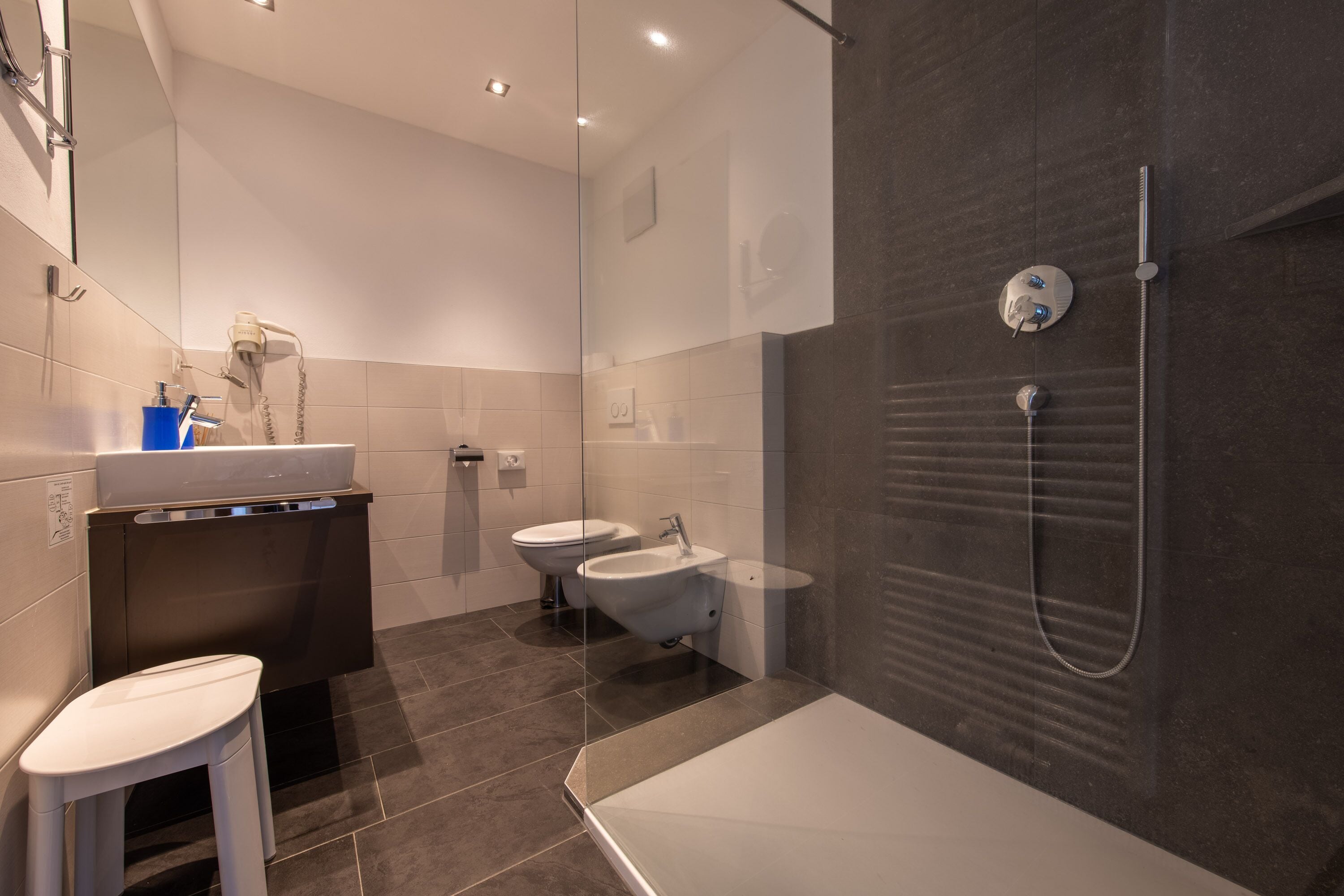 Ein modernes Badezimmer mit Duschkabine, Badewanne, Toilette und Waschbecken.