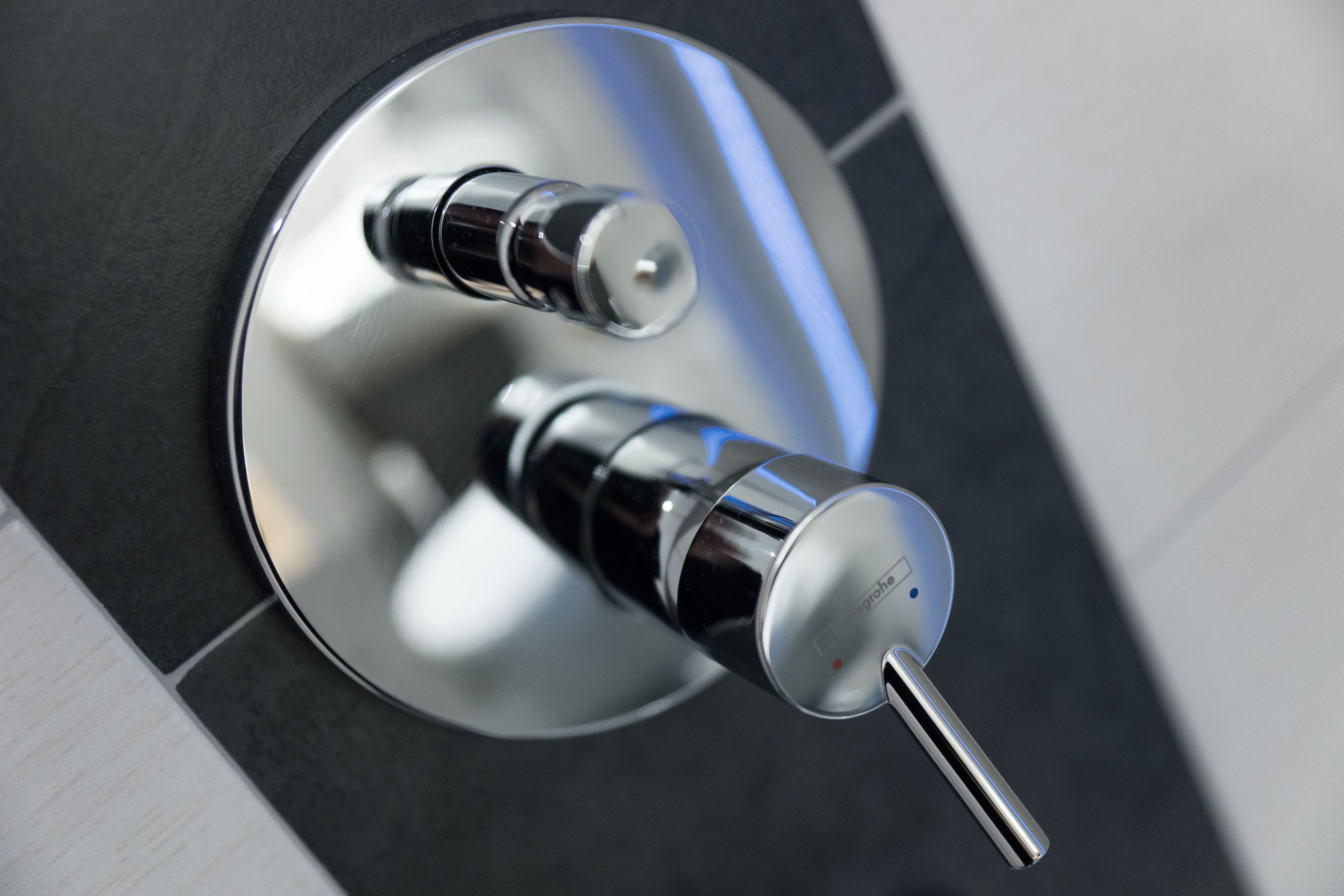A modern bathroom with a sleek, chrome faucet and a circular mirror.