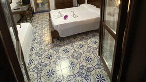 Une chambre à coucher comprenant un lit, une armoire en bois, un téléviseur et une salle de bain avec des toilettes.