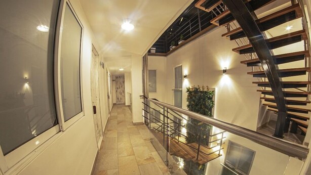 A modern interior with a spiral staircase, a glass railing, and a view of the lower level. - Hostal Casa Victoria (Cartagena)