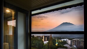 A room with a view of a mountain at sunset, a small window with a lantern, and a stone water feature. - Yumoto Niseko Prince Hotel Hirafutei (Kutchan)