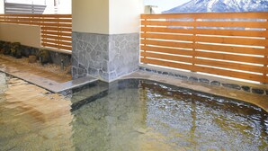 A pool area with stone and wooden flooring, a wooden fence, and a view of a snow-capped mountain. - Yumoto Niseko Prince Hotel Hirafutei (Kutchan)