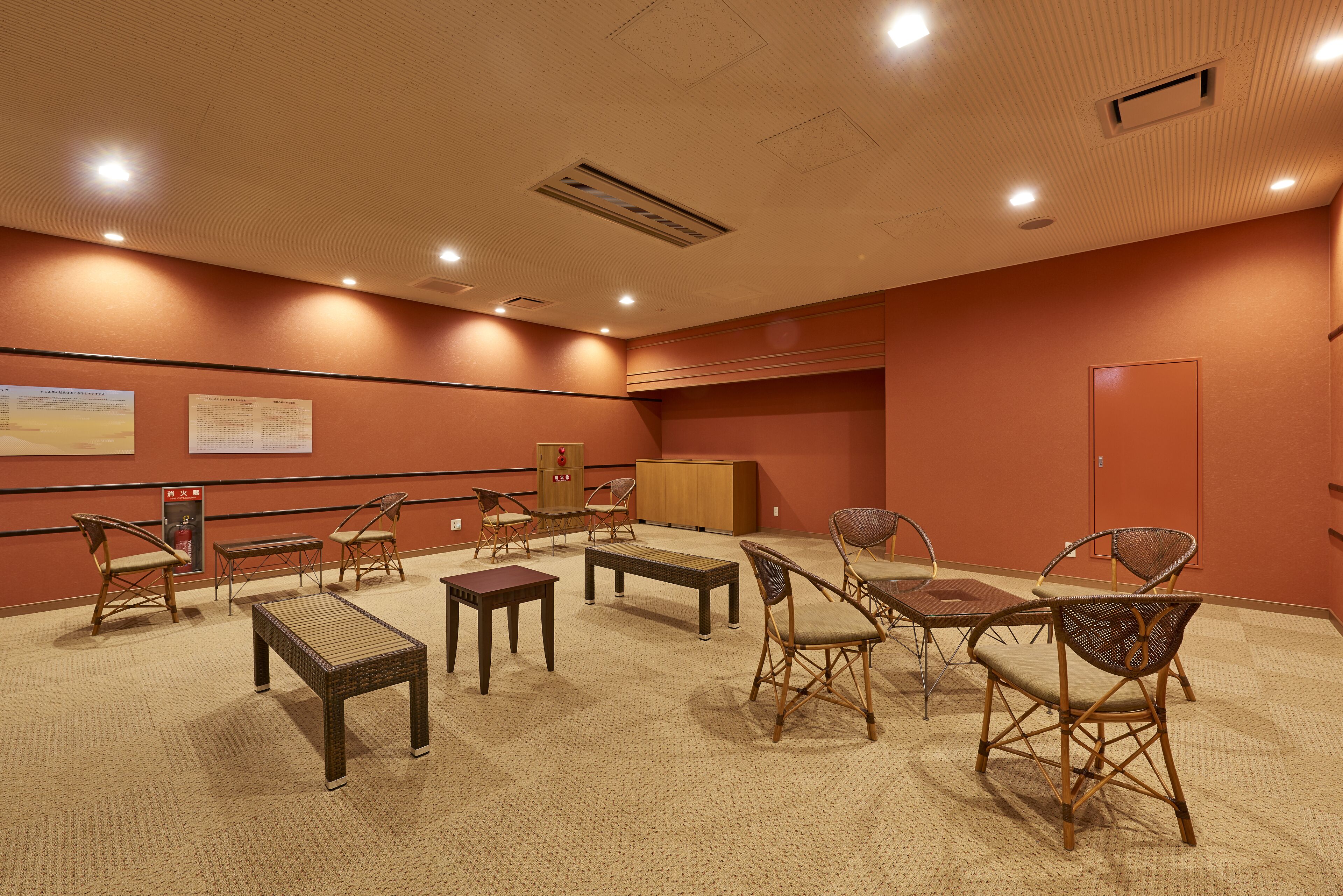 A conference room with a carpeted floor, wooden furniture, and a wooden cabinet.