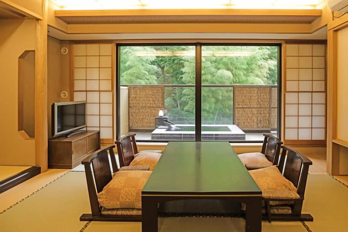 Une pièce de style japonais traditionnel, avec un sol recouvert de tatamis, une table basse et des coussins.